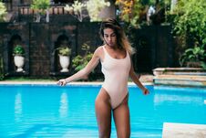 Amazing Girl In A White Bikini Sunbathing Near A Pool With Blue Water. Model With A Sports Figure Is Resting. Young Royalty Free Stock Image Amazing Girl In A White Bikini Sunbathing Near A Pool With Blue Water. Model With A Sports Figure Is Resting. Young Royalty Free Stock Image