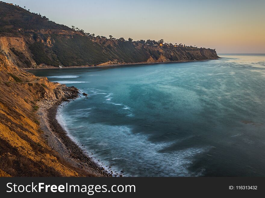Long-exposure elevated view of Bluff Clove with waves crashing onto the shore at sunset, Palos Verdes Estates, California. Long-exposure elevated view of Bluff Clove with waves crashing onto the shore at sunset, Palos Verdes Estates, California
