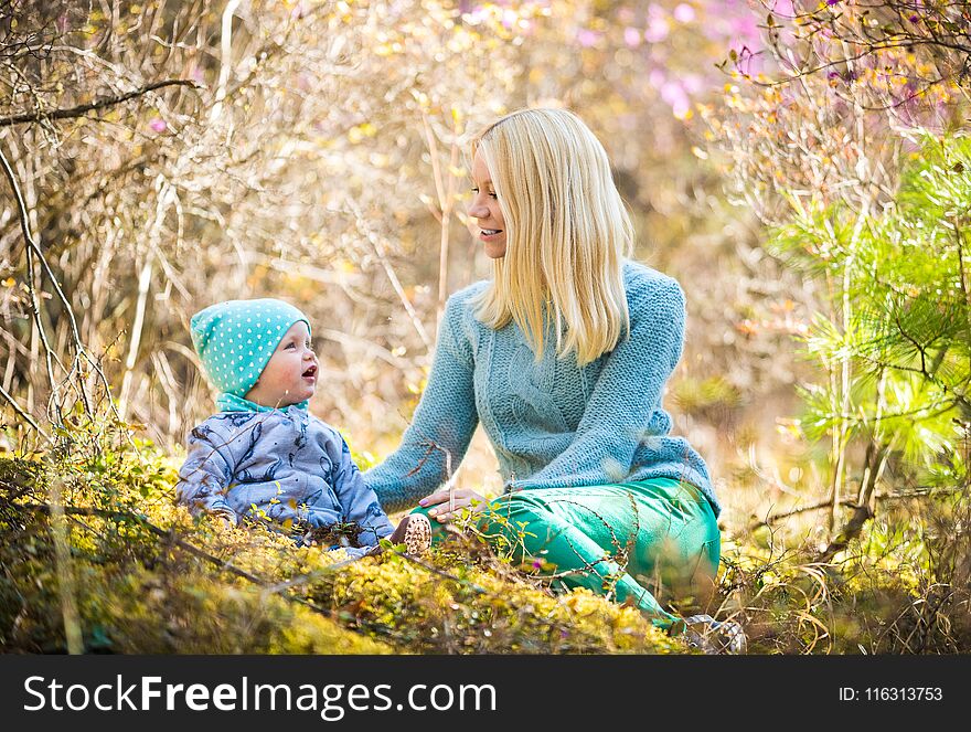 Happy Woman And Baby Girl In The Blooming Spring Forest With Rosemary