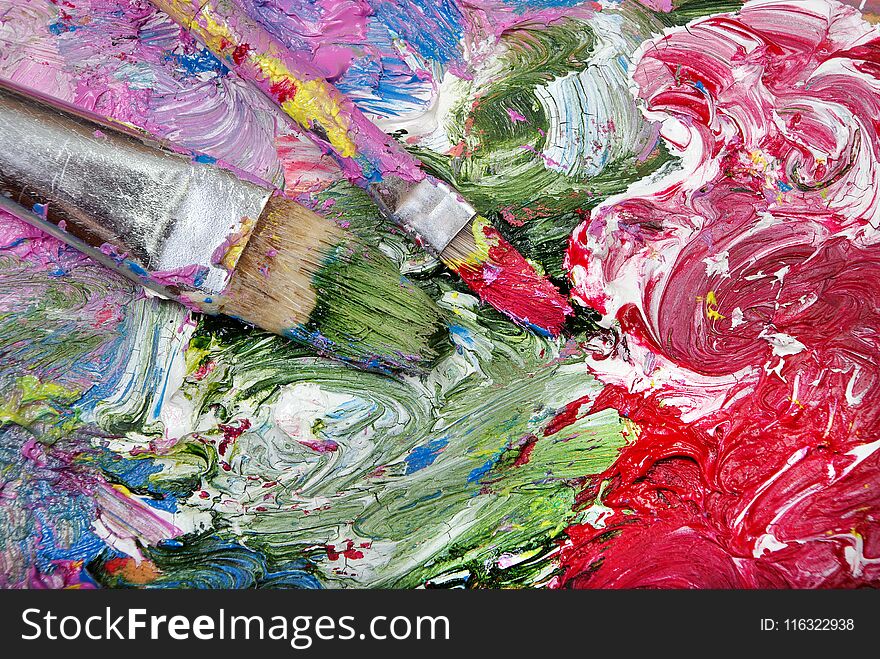 A palette of artists and brushes. brush strokes close up.