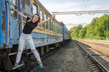 A Young Beautiful Girl Is Standing On The Step Of An Old Railway Carriage, A Departing Train Stock Photos