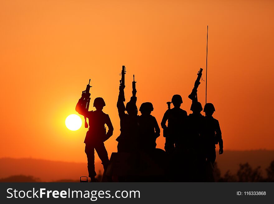 Soldiers silhouettes against a sunset.