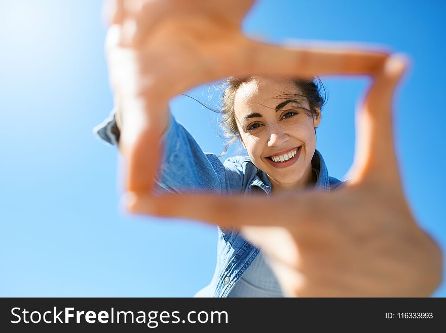 Portrait of a young attractive woman on the blue sky background