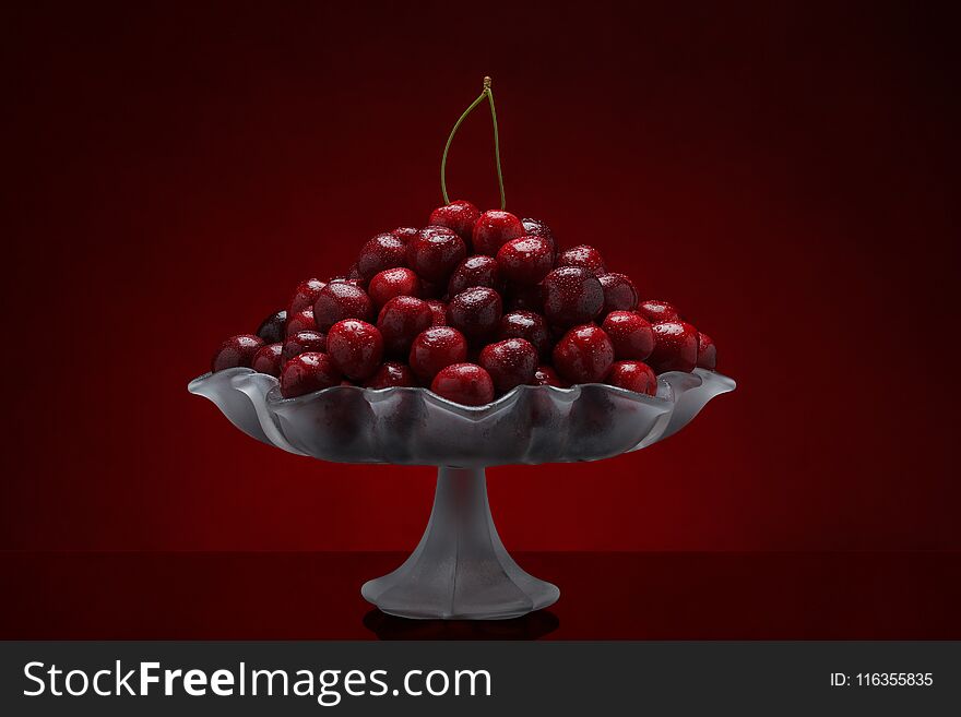 Pile of freshly washed sweet cherry fruits in a glass vase