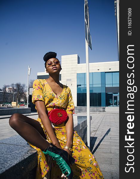 Woman in Yellow V-neck Dress Sitting on Outdoor Bench