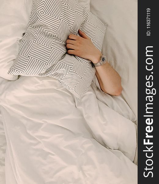 Person Holding Gray and White Throw Pillow