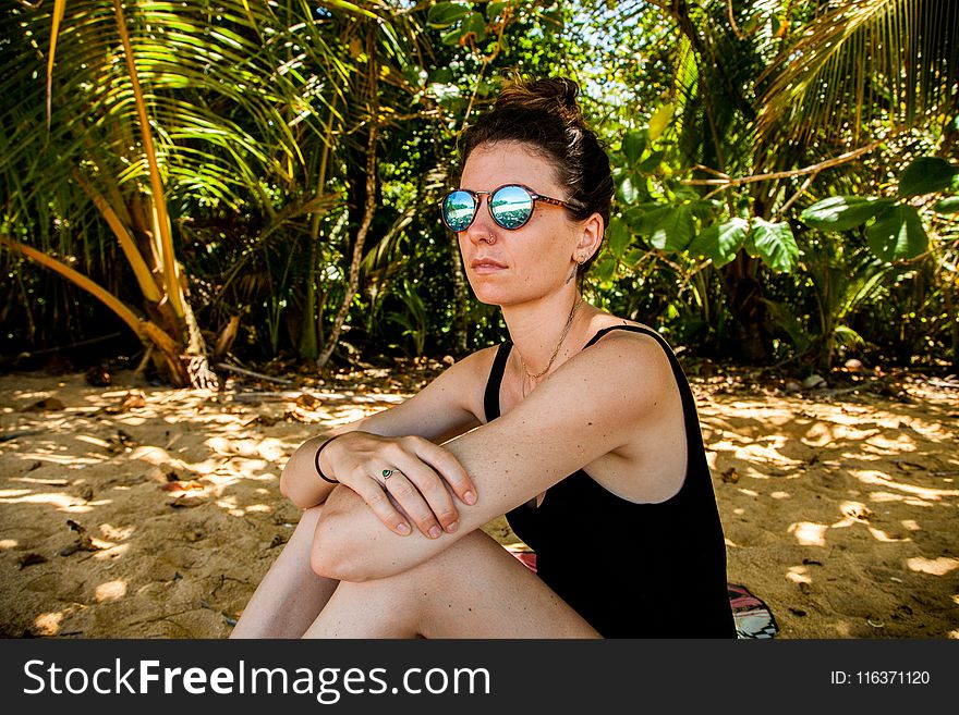 Woman in Black Monokini Sitting on Gray Sand