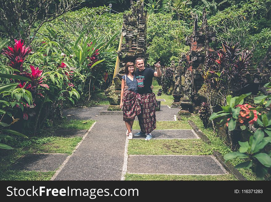 Woman and Man Standing Together and Looking on Flower Garden