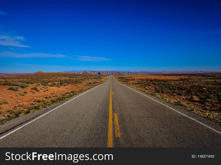 Straight Road Surrounded With Grass