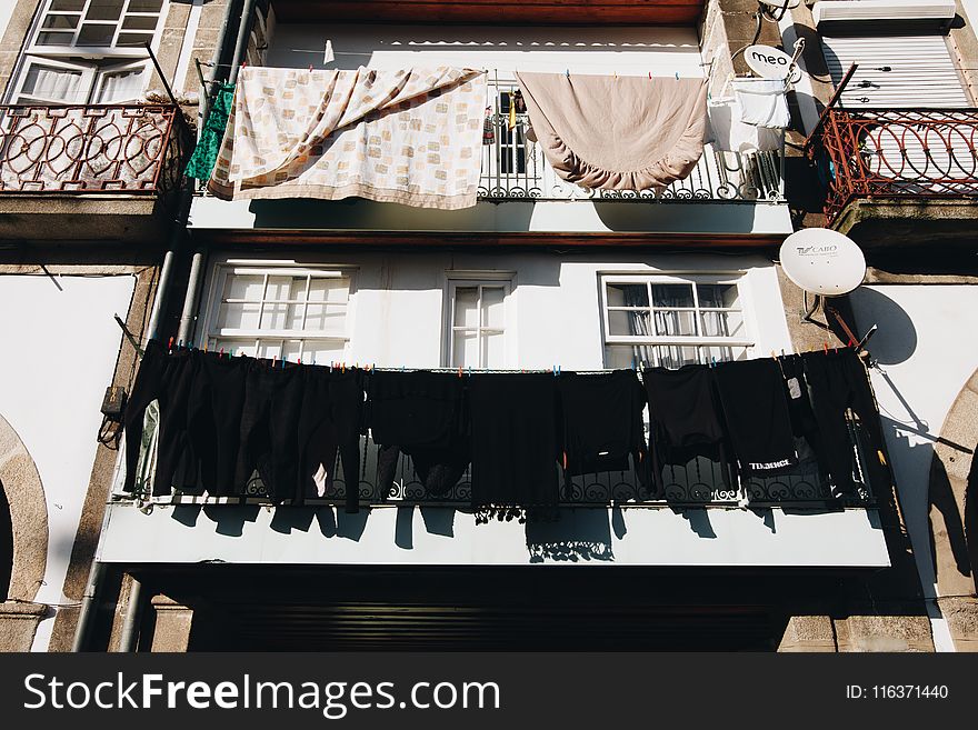 Close Up Photo of Black Clothes Hanged Outside Window