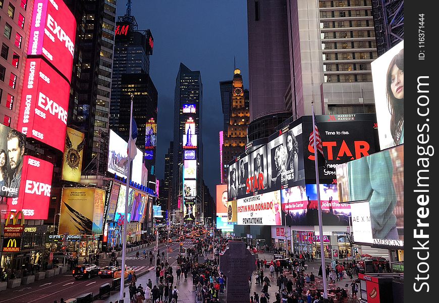 Crowd Walking Between Lighted Buildings During Nighttime