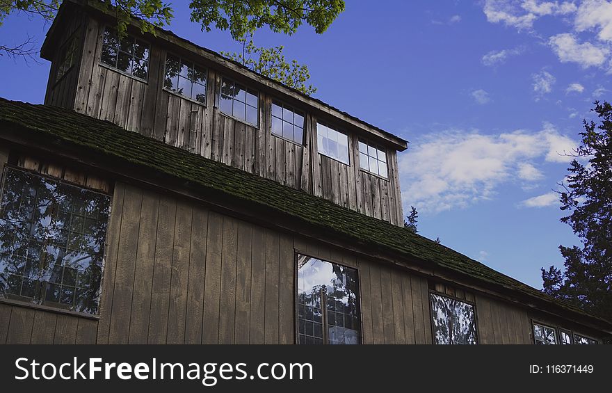 Brown Wooden House With Window Glass Under Clear Cloudy Sky