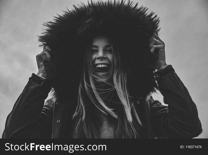 Grayscale Photo Of Laughing Woman Holding Her Hat