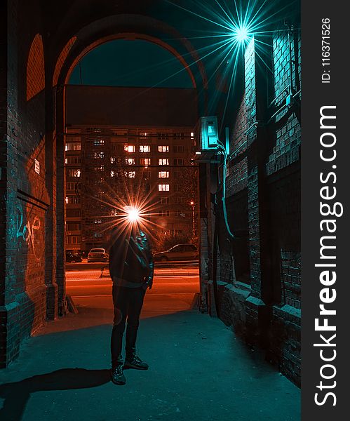 Photo of Man in Jacket Standing in Alley