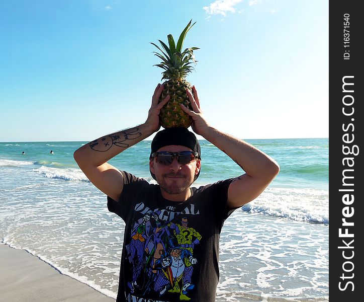Photography of a Man Holding Pineapple