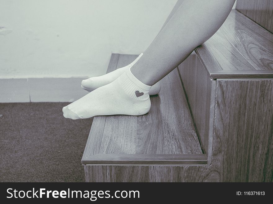 Person Wearing Pair of Foot Socks Sitting on Staircase