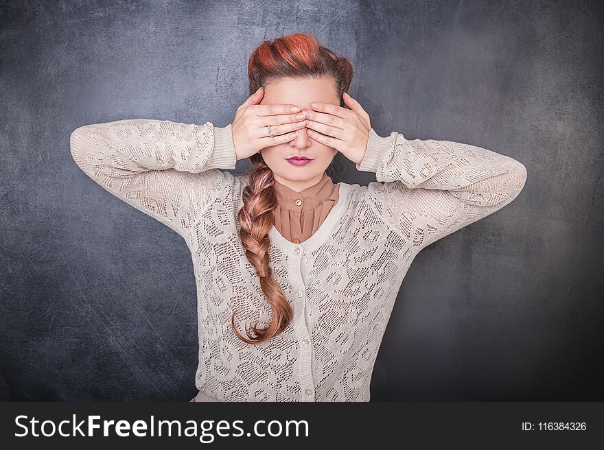 Stylish woman covering her eyes with hands on the chalkboard blackboard background