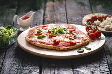 Italian Food, Cuisine. Margherita Pizza On A Black, Wooden Table With Igredients Like Tomatoes, Salad, Cheese, Mozzarella, Basil. Stock Photos