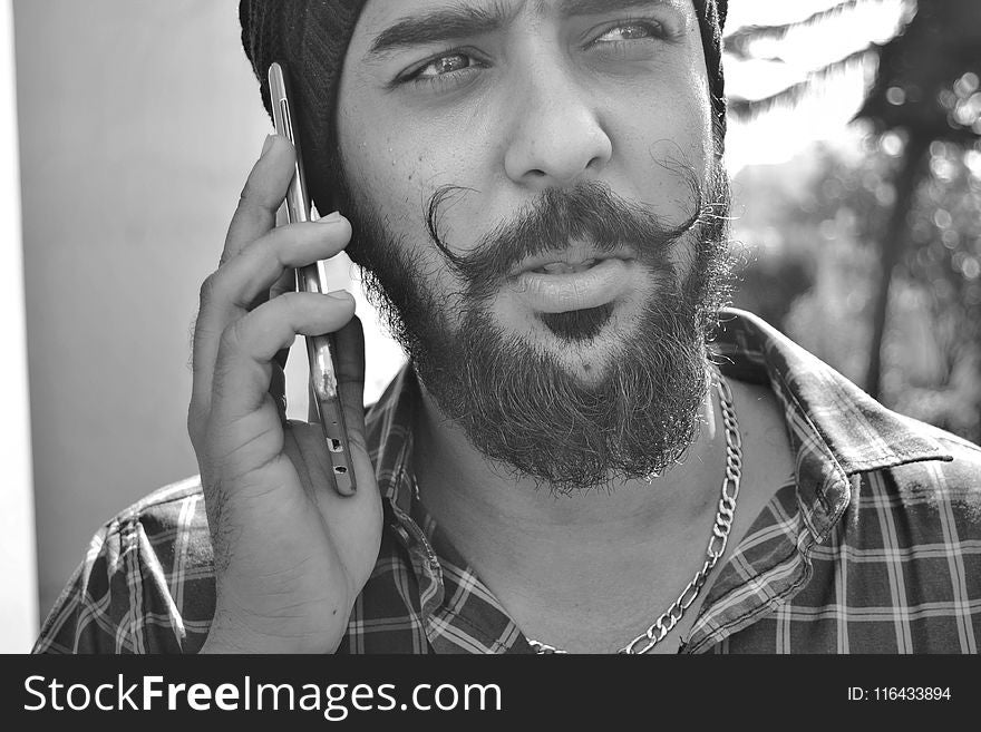 Grayscale Portrait Photo of Man Holding Phone