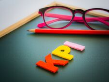 KPI Alphabet With Red Pencil And Pink Glasses Put On White Table Royalty Free Stock Photography