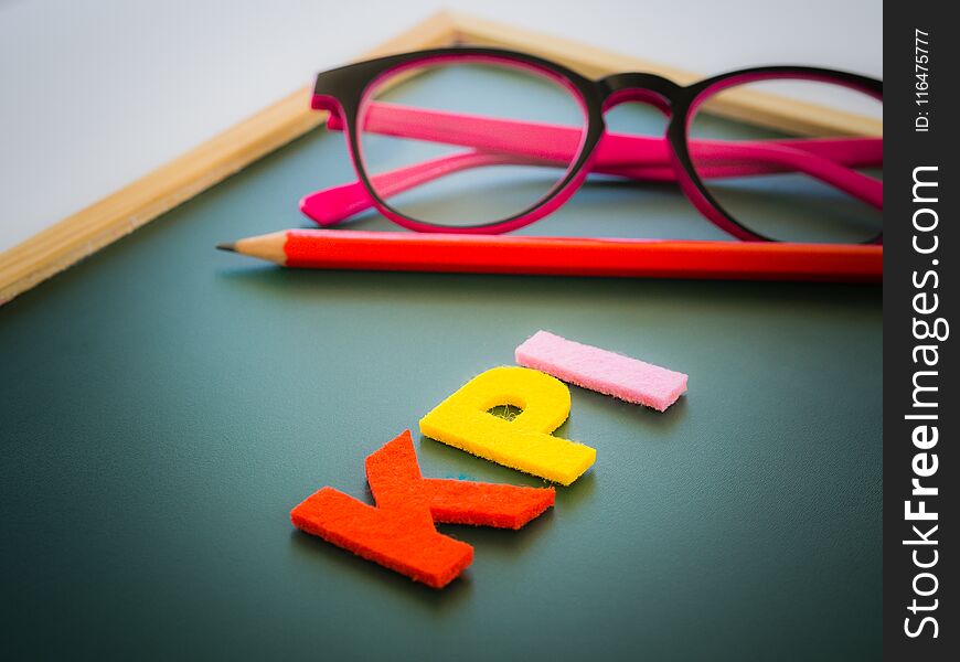KPI alphabet with red pencil and pink glasses put on white table