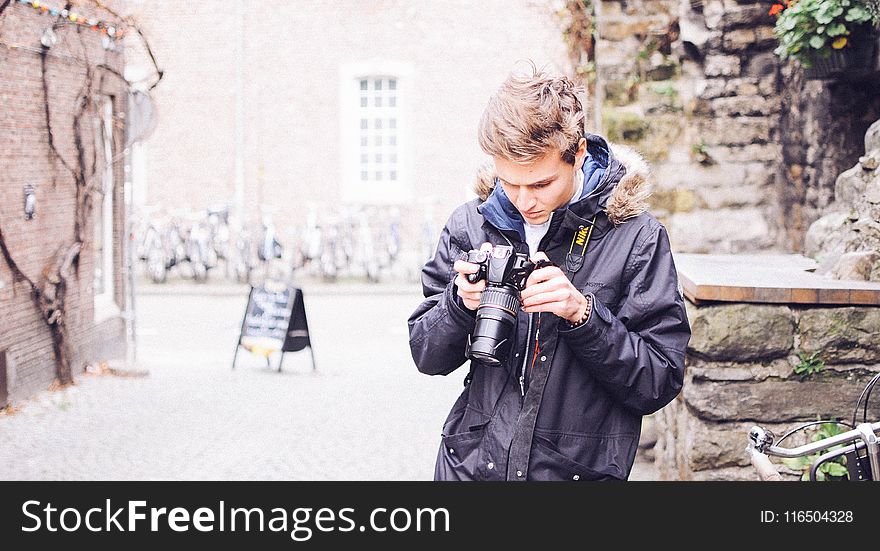 Man Holding Black Dslr Camera