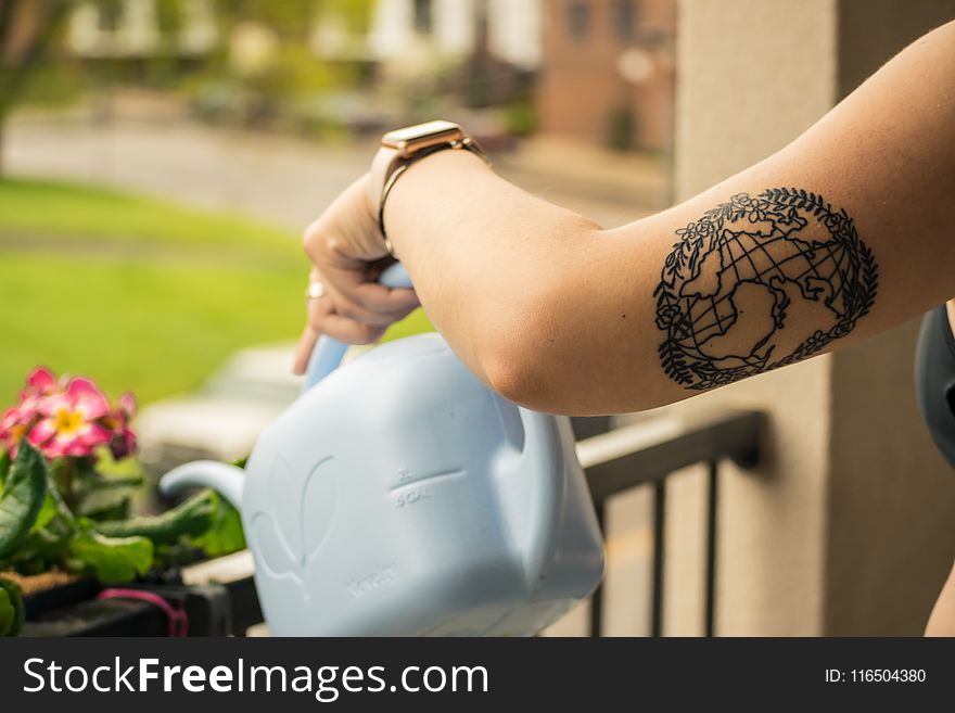 Person Holding Gray Plastic Watering Can