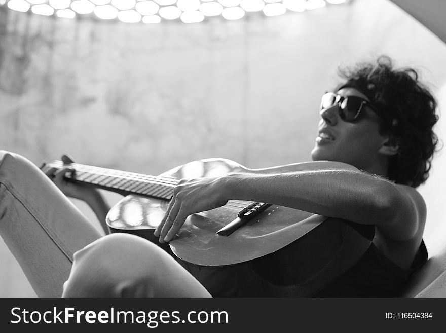Grayscale Photo of Man Playing Guitar