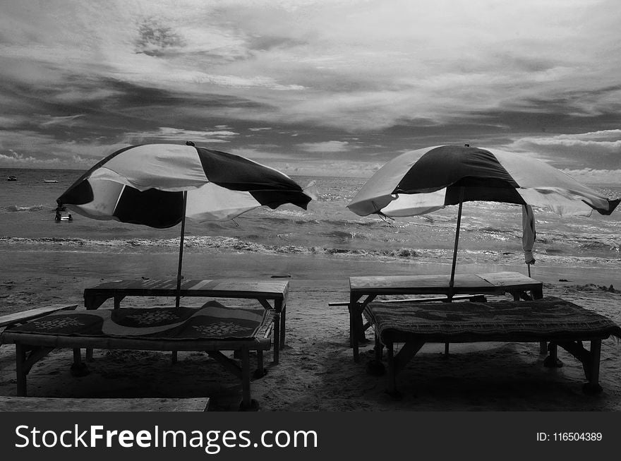 Grayscale Photography of Two Picnic Tables on Seashore