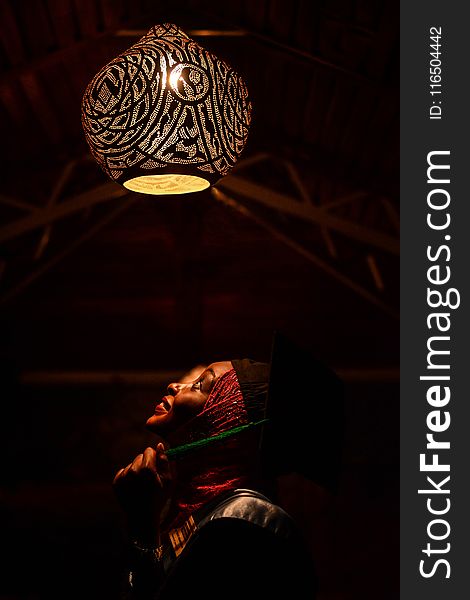 Woman Looking Upwards Toward Pendant Lamp