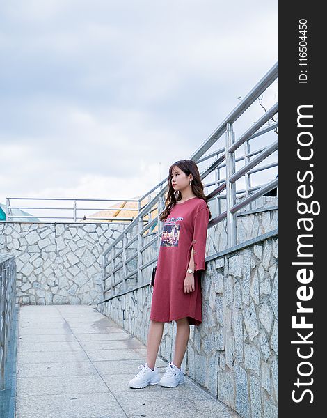 Woman Wearing Red Long-sleeved Shirt Dress Stands Next to Gray Metal Handrails
