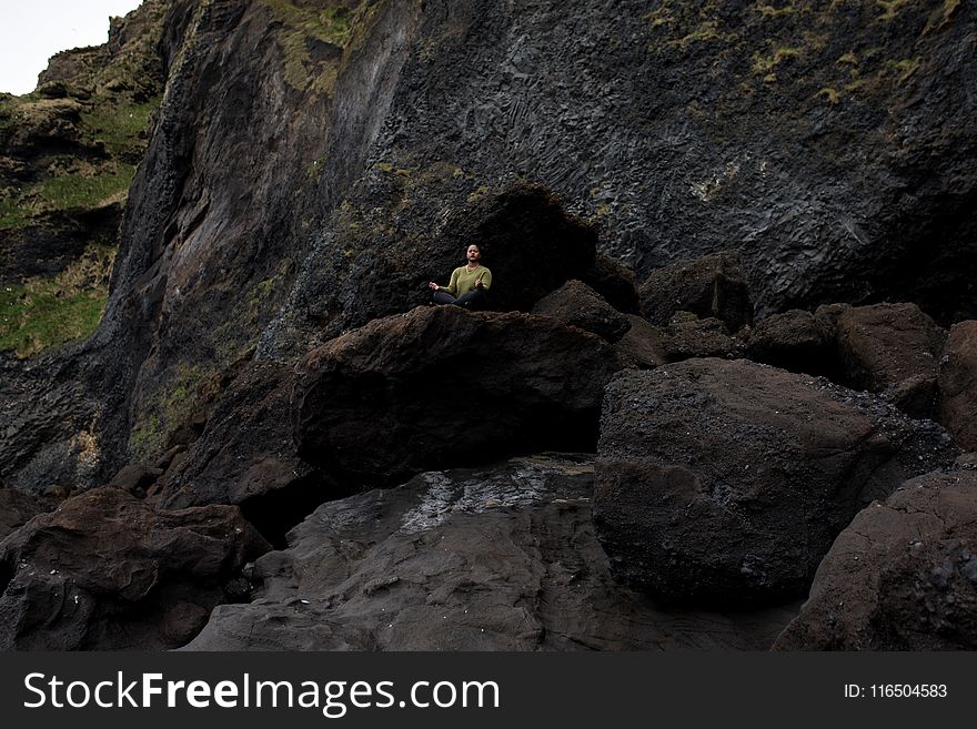 Photo Of Person Meditating On Top Of Rock