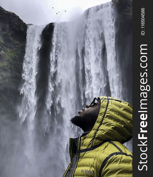 Photography of Man Wearing Bubble Hoodie Jacket Near Waterfalls