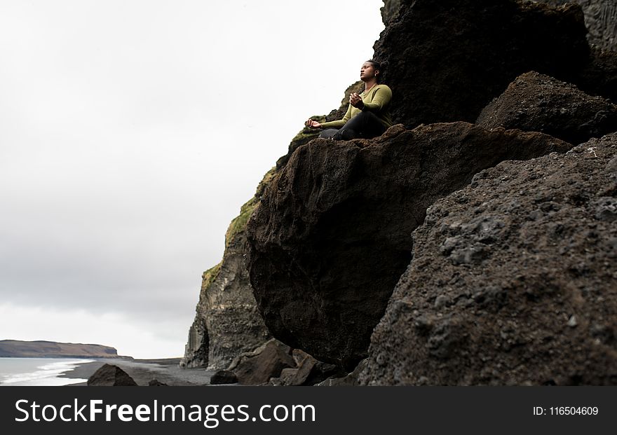 Woman Sitting on Rock Formation