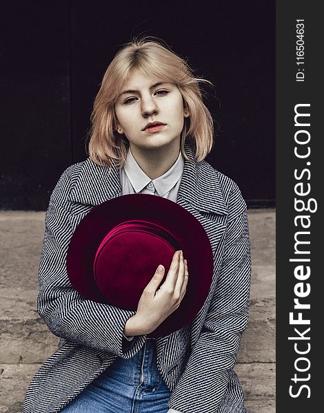 Woman In White Collared Top And Gray Coat Holding Red Fedora