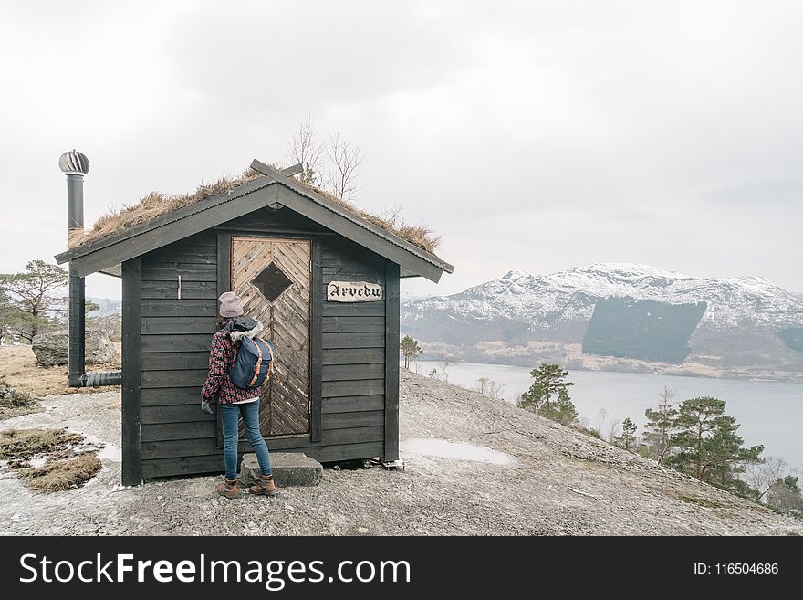 Person Standing in Front of Black Shed