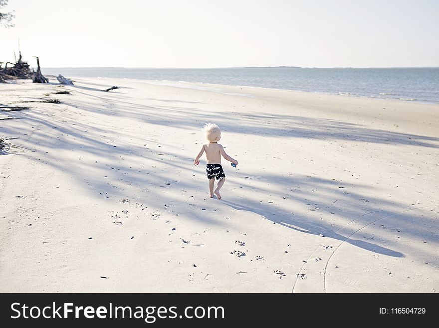 Boy Walking On Beach