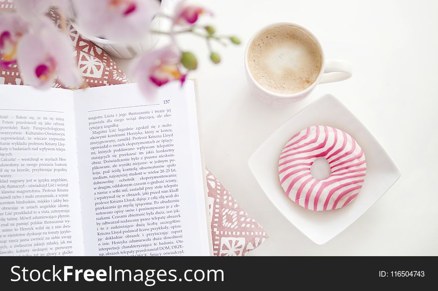 A book, cup of coffee and flavoured donut on Square White Ceramic Bowl