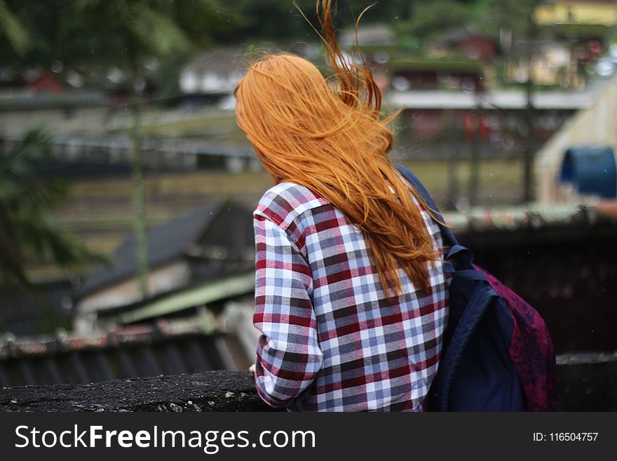 Person in White and Red Checkered Top With Black and Red Backpack in Shallow Focus Photography