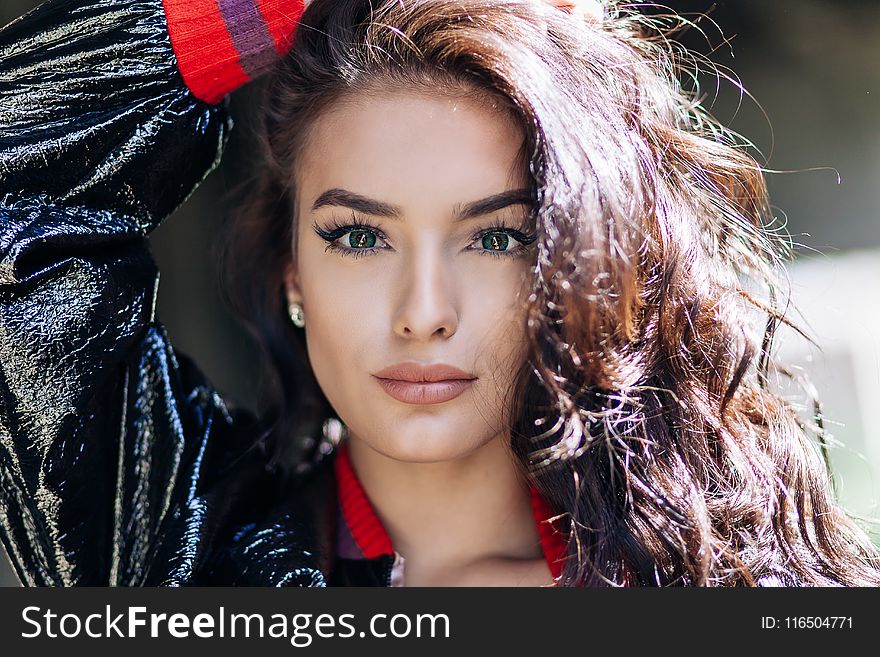 Woman in Black and Red Jacket Holding Her Head Photo