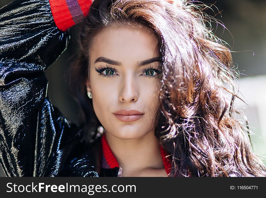 Woman In Black And Red Jacket Holding Her Head Photo