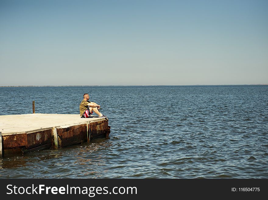 Man Sitting on Dock