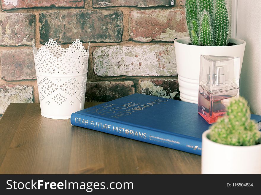 Blue Book on Brown Wooden Table with flower vases