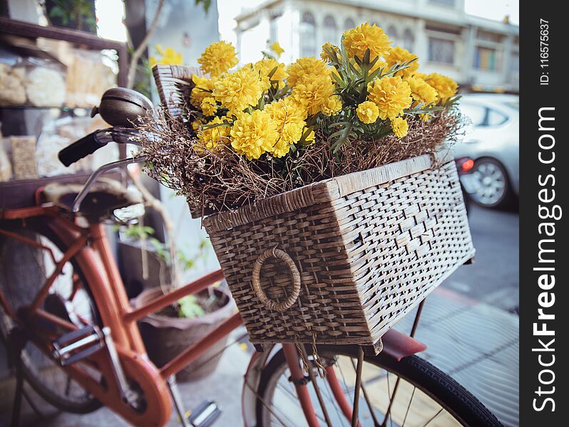 Closeup picture of a vintage bike with yellow flowers in a basket