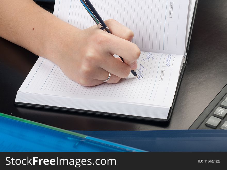 Young woman writing with pen on paper