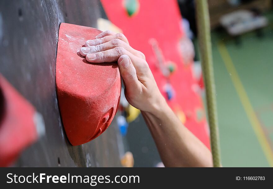 The man is practicing on the climbing wall, closeup shot