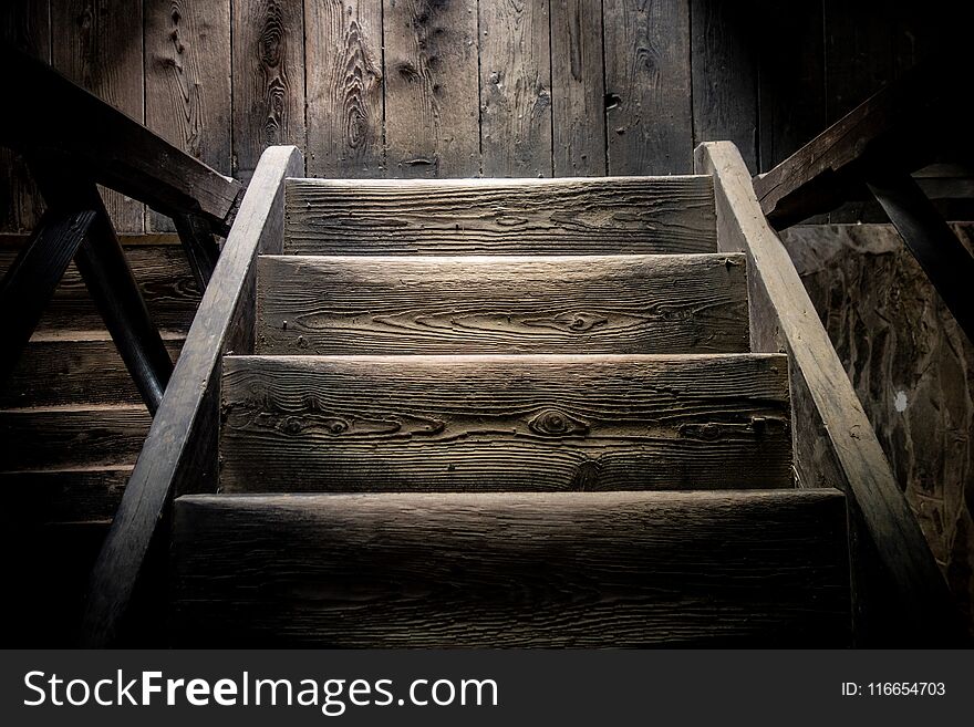 Very old wooden steps in the darkness with a small amount of light creating shadows