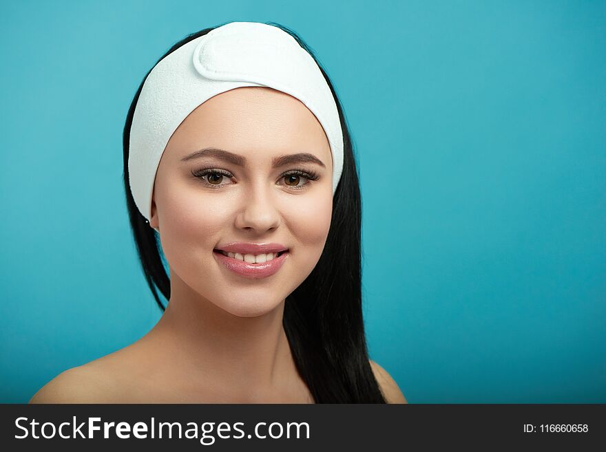 Portrait of smiling woman wearing white cosmetological headbandage.Waiting for beaty salon procedures and professinal master. Smoth, young, healthy skin. Beatiful face. Feeling happy, satisfied.