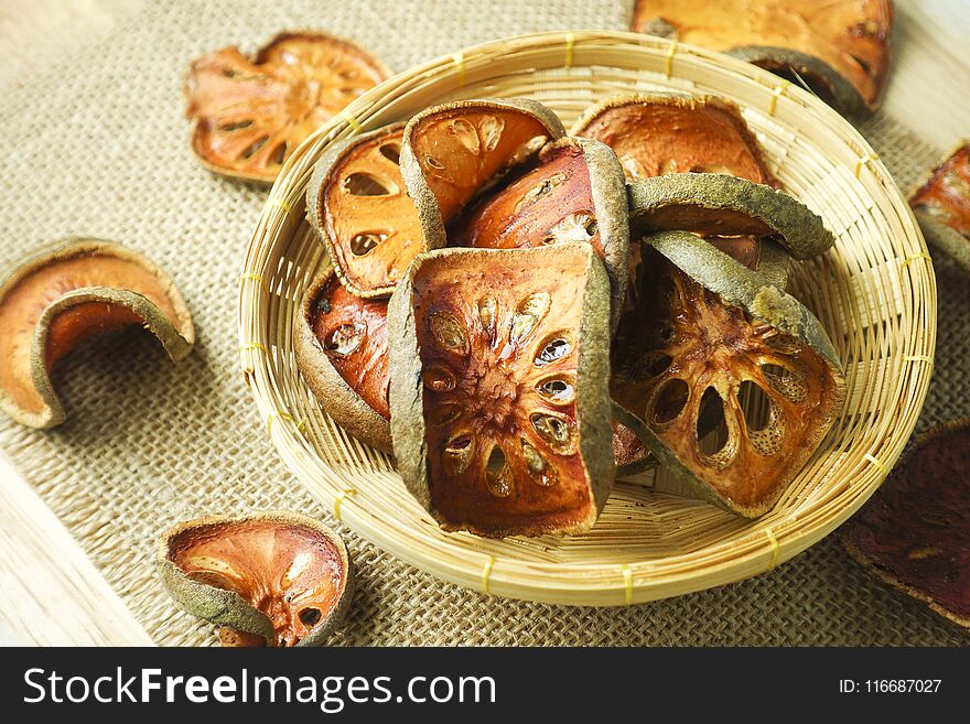 Slices of dry bael fruit in basket, close-up