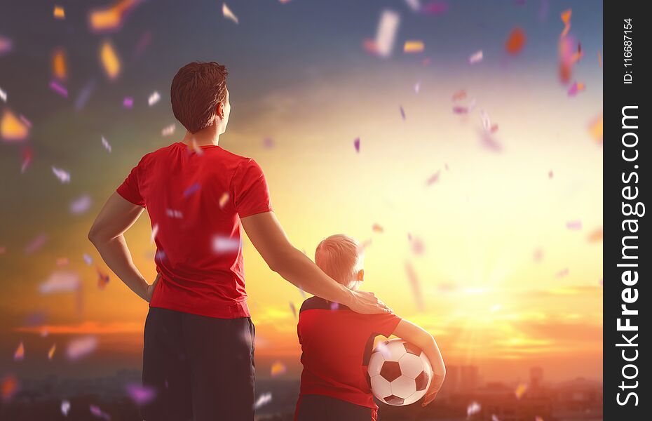 Cute little child dreaming of becoming a soccer player. Boy with men playing football on sunset. Family sport. Cute little child dreaming of becoming a soccer player. Boy with men playing football on sunset. Family sport.